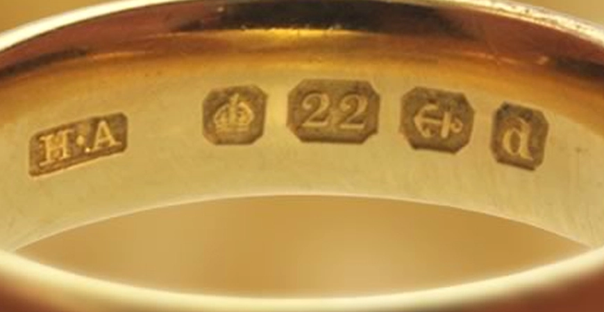 Gold hallmark stamps inside a ring band